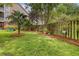 Landscaped backyard features a wooden fence, a variety of trees, green grass and seating at 9316 Sweetbay Ct, Ladson, SC 29456