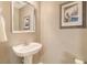 Small powder room features an attractive mirror, framed print, pedestal sink, and silver fixtures at 9316 Sweetbay Ct, Ladson, SC 29456