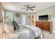 Spacious bedroom featuring a television, dresser, and entry into a bathroom, offering a luxurious retreat at 9316 Sweetbay Ct, Ladson, SC 29456