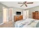 Bedroom featuring carpeted floors, ceiling fan, and ample storage with three separate door entrances at 9316 Sweetbay Ct, Ladson, SC 29456