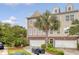 Inviting townhome featuring a two-car garage, tropical landscaping, and a well-maintained lawn at 9316 Sweetbay Ct, Ladson, SC 29456