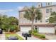 Charming townhome featuring a two-car garage, a well-manicured lawn, and tropical landscaping at 9316 Sweetbay Ct, Ladson, SC 29456