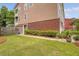 Exterior shot showing an expansive lawn, brick base, and meticulously maintained landscaping at 9316 Sweetbay Ct, Ladson, SC 29456