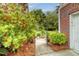 Close-up of a meticulously landscaped front yard with vibrant foliage and brick accents at 9316 Sweetbay Ct, Ladson, SC 29456