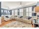 Bright living room with a large white sectional, plantation shutters and tasteful decor at 9316 Sweetbay Ct, Ladson, SC 29456