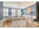 Living room features blue walls, a white leather sectional, and elegant furnishings at 9316 Sweetbay Ct, Ladson, SC 29456