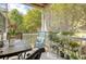 Relaxing covered porch with seating area surrounded by lush greenery and privacy screen at 9316 Sweetbay Ct, Ladson, SC 29456