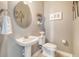 Charming powder room with pedestal sink, decorative mirror, and stylish wall art at 9316 Sweetbay Ct, Ladson, SC 29456