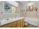 Bright bathroom with double sinks, a soaking tub, and decorative accents at 1005 Golden Aspen Dr, Moncks Corner, SC 29461