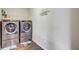 Modern laundry room featuring stacked washer and dryer units, complemented by unique decor and a 'Self-Serve Laundry' sign at 1005 Golden Aspen Dr, Moncks Corner, SC 29461