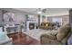 Cozy living room with fireplace, plush seating, a ceiling fan, and rich hardwood floors at 1005 Golden Aspen Dr, Moncks Corner, SC 29461