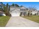 Inviting two-story home with gray siding, a well-kept lawn, and a driveway leading to a white garage door at 1019 Victoria Pointe Ln, Summerville, SC 29485