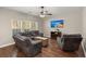 Cozy living room with hardwood floors, a ceiling fan, a large sectional sofa, and natural light from the windows at 1019 Victoria Pointe Ln, Summerville, SC 29485