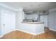 Well-lit kitchen featuring white cabinetry, stainless steel appliances, and breakfast bar overlooking living area at 1025 Riverland Woods Pl # 901, Charleston, SC 29412