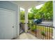Covered front porch with black metal railing offering views of the parking area and lush, green trees at 1025 Riverland Woods Pl # 901, Charleston, SC 29412