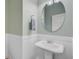 Powder room featuring a pedestal sink, round mirror and wainscoting at 108 Gaslight Blvd, Summerville, SC 29483
