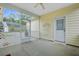 View of the screened in porch with a fan, white door and greenery outside at 108 Gaslight Blvd, Summerville, SC 29483