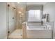 A luxurious bathroom features a glass-enclosed shower, a soaking tub, and stylish fixtures at 108 O'Leary Cir, Summerville, SC 29483