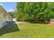 Well-kept backyard with green grass, mature trees, storage building, and space for outdoor activities at 111 Driver Ave, Summerville, SC 29483