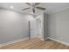 A bright bedroom with neutral paint, wood floors, trim, a ceiling fan, and an entry door at 111 Driver Ave, Summerville, SC 29483