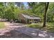 Charming home featuring a stone facade, inviting front porch and long driveway surrounded by lush greenery at 111 Garden Hill Rd, Summerville, SC 29483