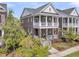Charming two-story brick home with double front porches, white railings, and manicured landscaping at 112 Brailsford St, Charleston, SC 29492