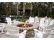 Outdoor community area featuring rocking chairs surrounding a brick fire pit with decorative lighting at 112 Brailsford St, Charleston, SC 29492