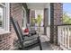 Cozy front porch with rocking chairs, brick columns, and a view of the neighborhood at 112 Brailsford St, Charleston, SC 29492