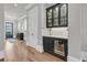 Hallway with hardwood floors, and a built-in bar area with glass-front cabinets and wine storage at 112 Brailsford St, Charleston, SC 29492
