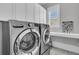 Well-equipped laundry room with stainless steel washer and dryer, ample storage, and natural light at 112 Brailsford St, Charleston, SC 29492