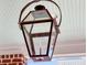 Elegant wrought iron gas lantern fixture hanging from a beadboard porch ceiling at 112 Brailsford St, Charleston, SC 29492