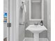 Stylish powder room features a pedestal sink, modern fixtures, and decorative mirror at 112 Brailsford St, Charleston, SC 29492