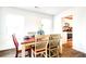 Bright dining room showcases wood floors, table set for dining, and view into the updated kitchen at 115 E East Sunrise Lane, Summerville, SC 29486