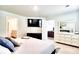 Bright main bedroom boasts a dresser with TV and an adjacent bath and walk-in closet at 115 E East Sunrise Lane, Summerville, SC 29486