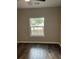 Bright bedroom with dark hardwood floors and a large window overlooking trees at 1300 Park West Blvd # 516, Mount Pleasant, SC 29466