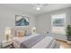 A well-lit staged bedroom showcases a comfortable bed and neighborhood views from the window at 1402 Camp Rd # 8B, Charleston, SC 29412
