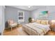 Bright bedroom featuring a white bed frame, wicker chair, and beach-themed artwork at 1402 Camp Rd # 8B, Charleston, SC 29412
