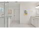 This bright bathroom features white cabinets, a tiled floor and a glass enclosed bathtub and shower at 1454 Seminole St, Mount Pleasant, SC 29464