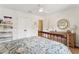 Bedroom features a wood frame bed, white walls, a ceiling fan, and a dresser with a circular mirror at 1454 Seminole St, Mount Pleasant, SC 29464