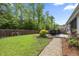 Private backyard with a stone patio, lush lawn, and a wood fence for relaxing and entertaining at 1513 Thin Pine Dr, Johns Island, SC 29455