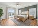 Bright bedroom features a large bed, gray accent wall, modern lighting and water view at 1614 Teal Marsh Rd, Charleston, SC 29412