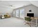 Bright bonus room features neutral walls, plush carpet, desk, and a comfortable green sofa at 1614 Teal Marsh Rd, Charleston, SC 29412
