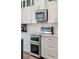 Close-up of kitchen appliances with white cabinets and subway tile backsplash at 1614 Teal Marsh Rd, Charleston, SC 29412