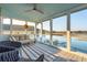 Relaxing screened porch features plush seating, a ceiling fan, and beautiful water views at 1614 Teal Marsh Rd, Charleston, SC 29412