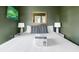 Close-up of a queen-sized bed with olive green walls, lamps, mirror, and artwork at 162 Spring St # D, Charleston, SC 29403