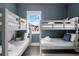 Bedroom featuring 3 grey bunk beds, blue walls, hardwood floors, rug, and outside view at 162 Spring St # D, Charleston, SC 29403