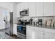 Well-lit kitchen features stainless steel appliances and white cabinets at 162 Spring St # D, Charleston, SC 29403