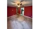 Living room featuring red walls, tile flooring, and a ceiling fan with doorway to kitchen at 1633 Southwick Dr, Johns Island, SC 29455
