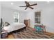 Bright bedroom features two sunny windows, a ceiling fan, and a decorative diamond-patterned rug at 1637 Pinckney Park Dr, Charleston, SC 29407