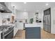 Bright kitchen boasts white cabinetry, stainless steel appliances, a farmhouse sink, and a blue island at 1637 Pinckney Park Dr, Charleston, SC 29407